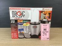 Full boxed set of Magic Bullet Deluxe 22-piece blender/mixer system with label and box artwork.