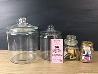 All four pantry jars shown together on a wooden surface with a black backdrop, including a label with lot details.