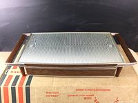 Front view of Salton Hooray Model H-140D automatic food warmer on original box, showing wooden sides and patterned glass top.