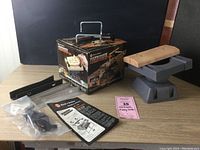 Workbench with vise, accessories and original box displayed on table.