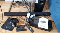 Image showing Samsung soundbar, remote controls, cables and Cambridge Soundworks Ambient Touch dock with user guide