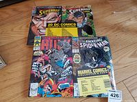 Overhead view of Marvel Comics Collector’s Pack and DC Comics Collector’s Pack shrink-wrapped bundles on hardwood floor