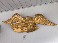 Overall front view of entire eagle sculpture mounted on wall