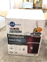 Box front showing In Sink Erator Evolution Select Plus garbage disposal, red color image, 3/4 HP, installation kit included