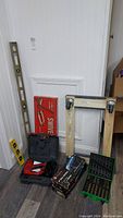 Full display of the lot including levels, power tools, moving dolly parts, and drill bits