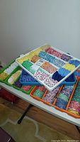 Photo showing trays with sorted English paper pieced quilter's hexagon fabric pieces in various colors and patterns.