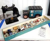 Overview showing sewing machine, tin truck and box of thimbles