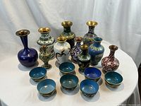 Group shot of 17 cloisonne vases and cups on a white backdrop