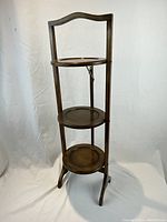 Front view of the 3-tier oak folding cake/pie stand showing all three tiers unfolded and the wood grain finish.