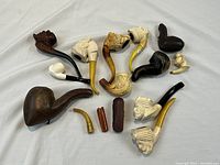 All eleven pipes laid out with loose stems and accessories visible