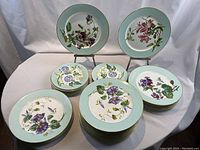 Overall view of stacked dinner and bread & butter plates showing floral patterns and blue rims