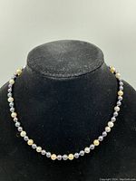 Full view of necklace displayed on black mannequin