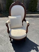 Front view of Victorian side chair with matching pillow showing carved wood frame and upholstered seat and back in light fabric.