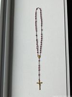 Full view of the amethyst-colored rosary showing bead chain and crucifix