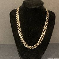 Front view of gold tone box-link chain necklace on black display bust.