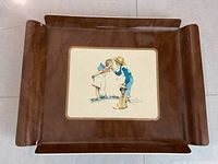 Full view of the brown acrylic serving tray showing the overall shape and the central printed Norman Rockwell image.