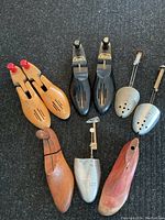 All six shoe care tools displayed including wooden shoe stretchers, metal shoe stretchers, and a shoehorn on the surface.