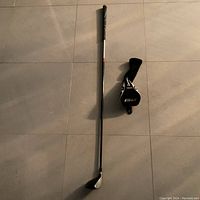 Full view of TaylorMade R9 3 wood golf club alongside its matching headcover on tiled floor