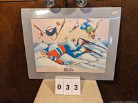 Full view of vintage signed Peter print titled 'Moguls' showing colorful comical skiing scene and gray backing.