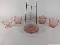 Full lot view showing 2 sugar bowls, 1 with lid, creamer, sherbet cup, and 4 sherbet plates on an easel
