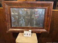 Full view of rectangular antique ogee wood framed mirror showing wood grain, frame style and size