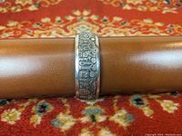 Full view of the front of the sterling silver Navajo carved cuff bracelet showing the pictorial scene in detail.