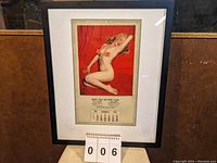 Full view of black framed calendar with white mat and two star-shaped stickers on glass