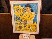 Framed print showing girl with sunflowers and vibrant blue background.
