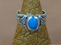 Front view of the sterling silver ring with oval lapis lazuli stone centered and etched Native American design on sides.