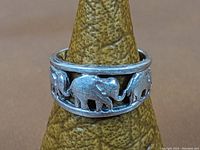 Front view of sterling silver open work ring showing detailed elephant motifs.