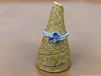 Front angled view of the sterling silver ring showing the two amethyst stones and part of the band with cubic zirconia.