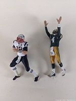 Front view of Tom Brady and Brett Favre statues showing full standing figures in action poses without bases.