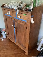 Front view of the cabinet showing two upper drawers, lower double doors and porcelain knobs