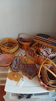 Photo showing multiple assorted Longaberger baskets in different sizes and shapes arranged on white plastic drawers, mostly decorated with patriotic fabric liners.