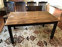 Front view of two-tone wood dining table with chairs in background