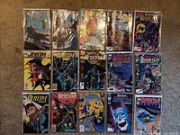 Top view of 15 bagged Detective Comics comic books in a 3 by 5 grid, showing full front covers with Batman and related characters.