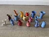 Photo showing full lot of 16 miniature pottery pieces including varied vases, pitchers, and candle holders in multiple colors.