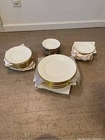 Full set of stacked plates grouped by size wrapped and placed on floor.