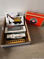 CAT crane in original styrofoam packaging with box next to it, displayed with three train cars inside a single box.