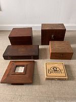 Full group of 6 items: four wooden boxes and one wooden picture frame with stepped design shown from above on floor
