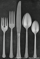 Photo of five silverplate flatware pieces including hollow cutter, fork, salad fork, tablespoon, and teaspoon from the Del Mar pattern by Oneida.