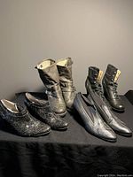 Group photo showing four pairs of women's boots and booties against plain background, black.