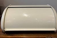 Front view of a white roll-top bread container for kitchen countertop storage.