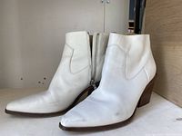 Side perspective of white leather rag & bone ankle boots showing wear marks, pointed toe, and wooden heel