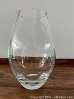 Front view of clear glass vase on wooden surface showing shape and clarity.