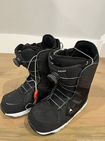 Pair of black women's Burton Limelight Boa snowboard boots with white soles, showing the front and side profile.
