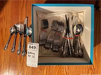 Full boxed set of silverware pieces for 12 people, organized in bundles.