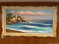 Full view of framed original coastal landscape painting with ocean waves, cliffs, lighthouse, and sailboats. Signed A Toro.