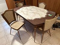 Overall view of the retro laminated table with four chairs around it, showing table top and chair design.