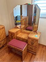 Front view of the vanity with three-way mirror and cushioned bench in front